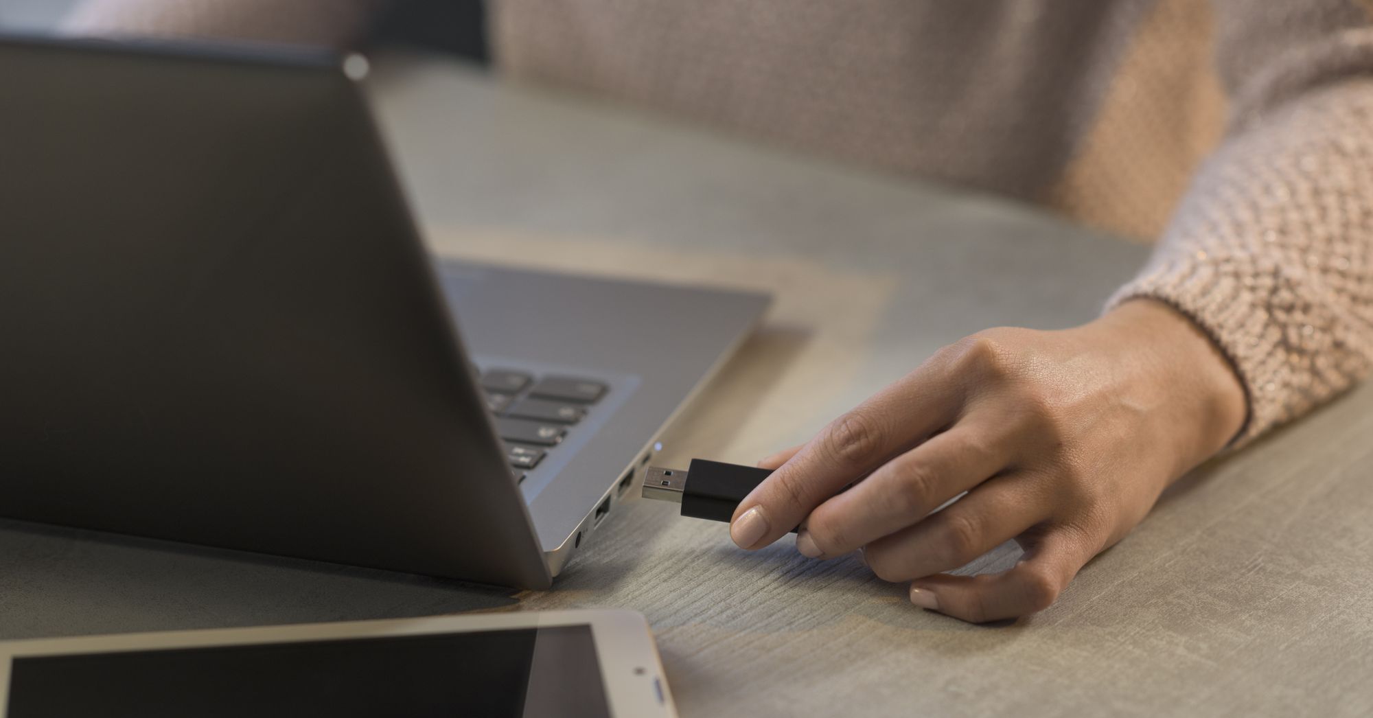 Kobieta podłączająca pamięć USB do laptopa